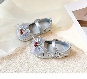 Detail view of sparkly silver girls' shoes with mesh bows and cherry charms
