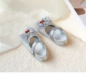 Detailed view of silver glitter girls princess shoes with organza bow and cherry ornament