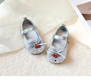 Detail view of silver glittery girls princess shoes with cherry bow and rhinestone