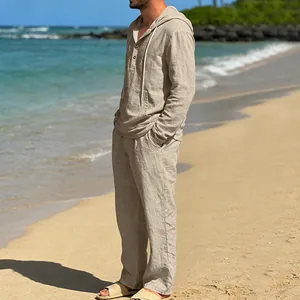 Herren Freizeitset aus beigem Leinen mit Kapuzen-Henley-Hemd und passender Hose am Strand