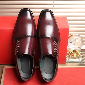 Detail van bordeauxrode zakelijke herenschoenen met zijveters en een elegante glanzende finish