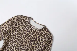 Detail view of a leopard print long sleeve bodysuit showing neck cutout and fabric texture.