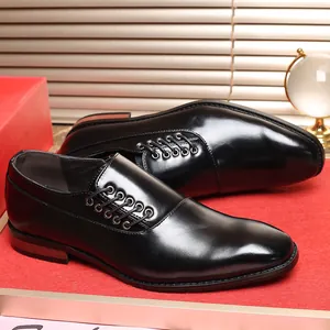 Detail van glanzende zwarte herenschoenen met vetersluiting aan de zijkant en een puntige neus.