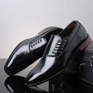 Detailweergave van zwarte formele herenschoenen op een lederen aktetas