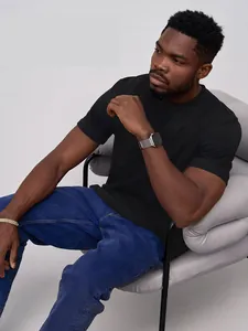 T-shirt noir oversize pour homme porté par un mannequin sur un fauteuil