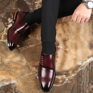 Close-up van heren bordeauxrode geklede schoenen van leer met unieke vetersluiting aan de zijkant.
