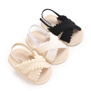 Detalle de sandalias suaves para bebé con correas de pompones en tres colores