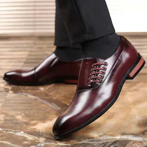 Detail van bordeauxrode herenschoenen met zijvetersluiting en een puntige neus