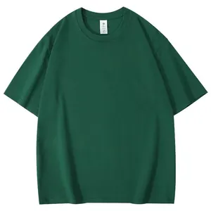 Vue de face d'un t-shirt à manches courtes vert foncé oversize à plat sur fond blanc.