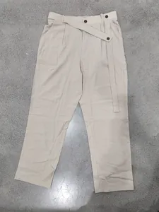Detailansicht der asymmetrischen geknöpften Taille bei beigen Leinenhosen