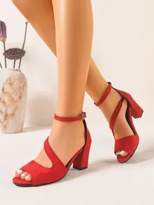 Close-up of elegant red suede chunky heel sandals featuring an ankle strap and open toe