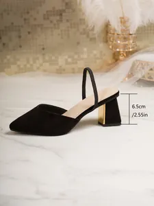 Detail view of black pointed-toe chunky heel pump with 6.5cm gold heel accent