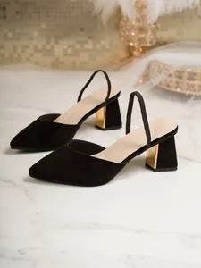 Elegant black suede pointed-toe slingbacks with striking chunky gold heels on marble.
