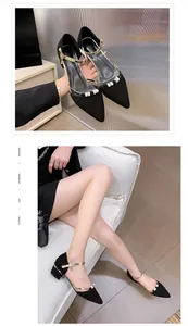 Detailed shot of black pointed-toe block heel shoes with gold straps and pearl accents