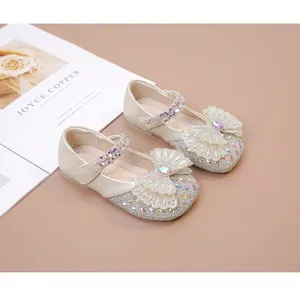 Vista detallada de los zapatos de princesa para niña con pedrería y lazo de mariposa.