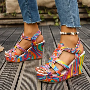 Detail view of colorful psychedelic print wedge sandals with strappy design and buckle.