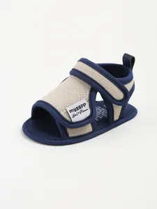 Close-up of cotton baby sandal with breathable design and navy blue Velcro straps.