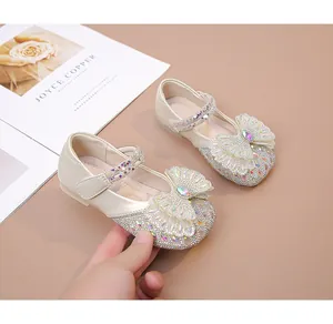 Detalle de zapatos de princesa marfil para niñas con brillantes diamantes y lazo