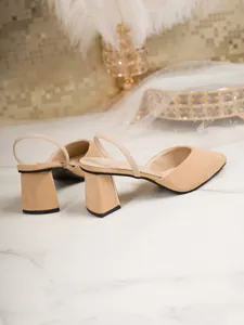 Close-up of beige suede slingback pumps with elegant block heel and gold detail
