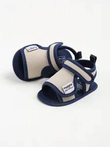 Macro view of blue and beige cotton baby walker sandals with velcro strap fastening