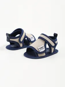 Close-up detail of navy blue and beige cotton baby sports sandals with velcro straps