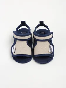 Top-down view of navy and beige cotton baby walking sandals for summer infants