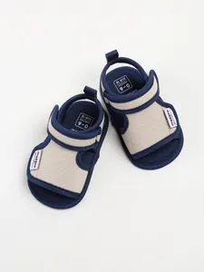 Top-down view of breathable navy and beige cotton baby sandals with soft soles