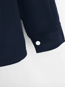 Vue détaillée du poignet d'une veste bleu marine pour homme avec bouton blanc net
