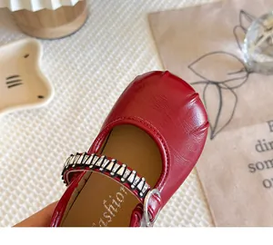 Detailed view of red French style Mary Jane girl shoe featuring a sparkling rhinestone strap.