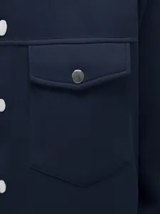 Gros plan sur la poche poitrine d'une veste cintrée pour homme bleu marine avec bouton pression.