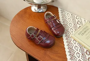Λεπτομέρεια από vintage μπορντό δερμάτινα παπούτσια για κορίτσια με φούντες