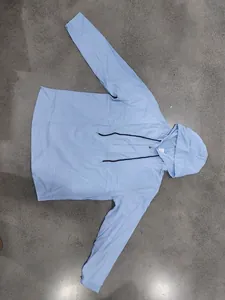 Detail showing a flat-laid light blue linen Henley hoodie with black drawstrings