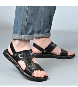 Detalle de las modernas sandalias de playa de cuero negro para hombre con suela blanda.