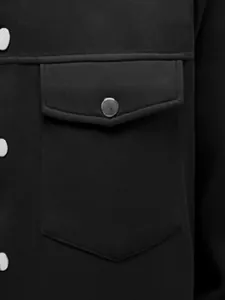 Détail d'une poche de poitrine avec bouton-pression métallique sur une veste noire pour hommes