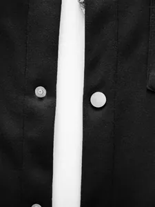 Détail d'une veste cintrée pour homme noire avec boutons-pression métalliques et texture maille