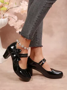 Dettaglio di scarpe Mary Jane in vernice nera con fiocco e tacchi larghi a blocco
