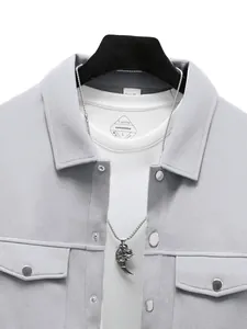 Gros plan d'une veste en daim synthétique gris clair avec col à revers et boutons-pression