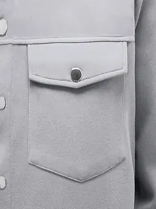 Détail de la poche d'une veste décontractée grise pour homme avec bouton pression.
