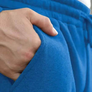 Close-up of blue men's casual sweatpants pocket showing soft fabric texture and design.