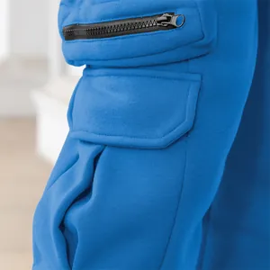Close-up detail of blue cargo pants featuring a side pocket with a black zipper