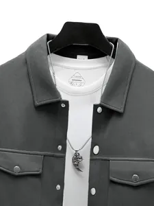 Gros plan d'une veste grise pour homme avec col à revers et boutons-pression argentés.