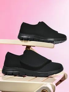 Vista laterale di scarpe da camminata nere in mesh traspirante con ampio velcro