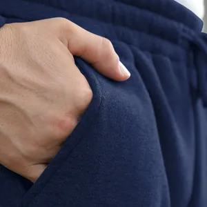 Detailed close-up showing the pocket and fabric texture of navy blue men's sweatpants