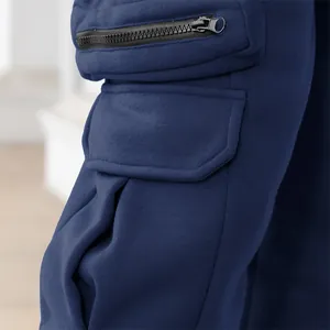 Close-up detail of functional side pockets and black zipper on navy men's cargo pants