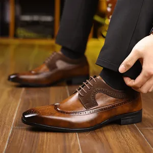 Λεπτομέρεια ανδρικών καφέ παπουτσιών Brogue με κλασικό σχέδιο και σκούρα κορδόνια.