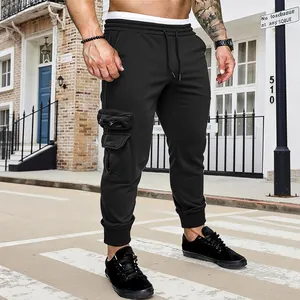 Men's black cargo sweatpants with multi-pockets and drawstring waist in street setting