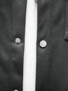 Gros plan sur les boutons-pression métalliques et le tissu texturé d'une veste pour hommes