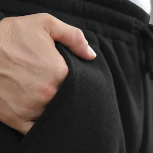 Macro detail of side pocket on black men's cotton drawstring joggers with soft fabric texture