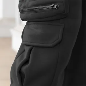 Detailed close-up of black cargo pants showing multi-pocket design and zipper accents