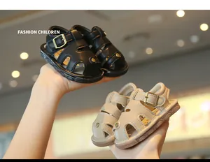 Detailed view of black and beige infant summer sandals with non-slip soft soles